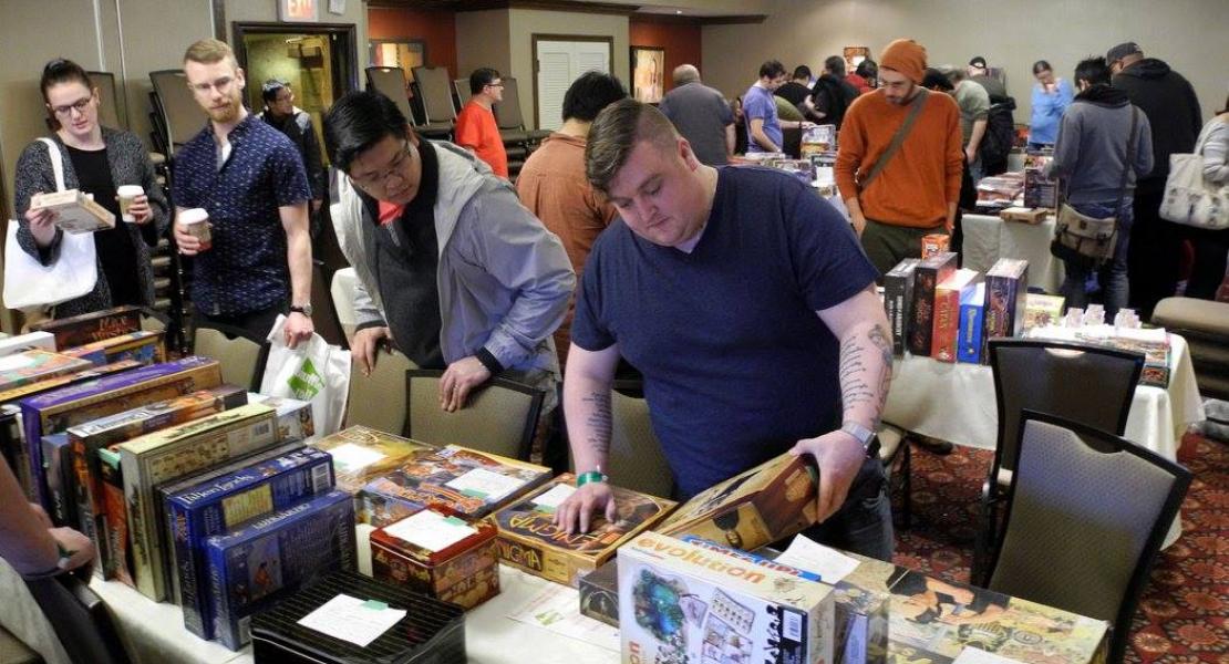 bring and buy auction table with gamers looking at boxes