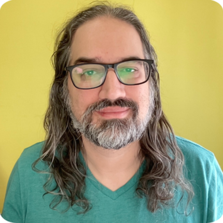 Jonathan Lavallee standing in front of a yellow background.